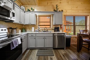 Enjoy meals in this kitchen with stainless steel appliances, granite countertop, and a dining area with a view.