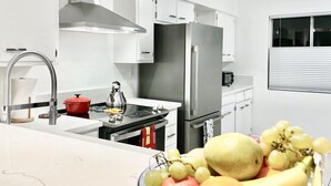 A modern kitchen with white cabinets, stainless steel appliances, and a fruit bowl on the counter. - BIG DISCOUNTS ! Fabulous DOWNTOWN Palm Springs! Gorgeous Mid Century. BEST area! (Palm Springs)