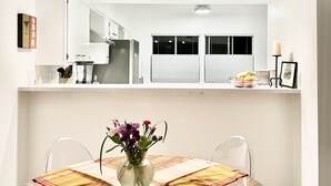 A modern kitchen with white cabinets, a built-in oven, and a window with closed blinds. - BIG DISCOUNTS ! Fabulous DOWNTOWN Palm Springs! Gorgeous Mid Century. BEST area! (Palm Springs)