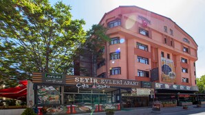 Un immeuble à plusieurs étages qui abrite un restaurant appelé « SEYIR EVLERIAPART » au rez-de-chaussée.