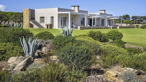 Een modern huis met twee verdiepingen, een overdekte patio en een stenen trap.