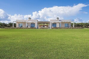 A modern two-story house with a large lawn in front.