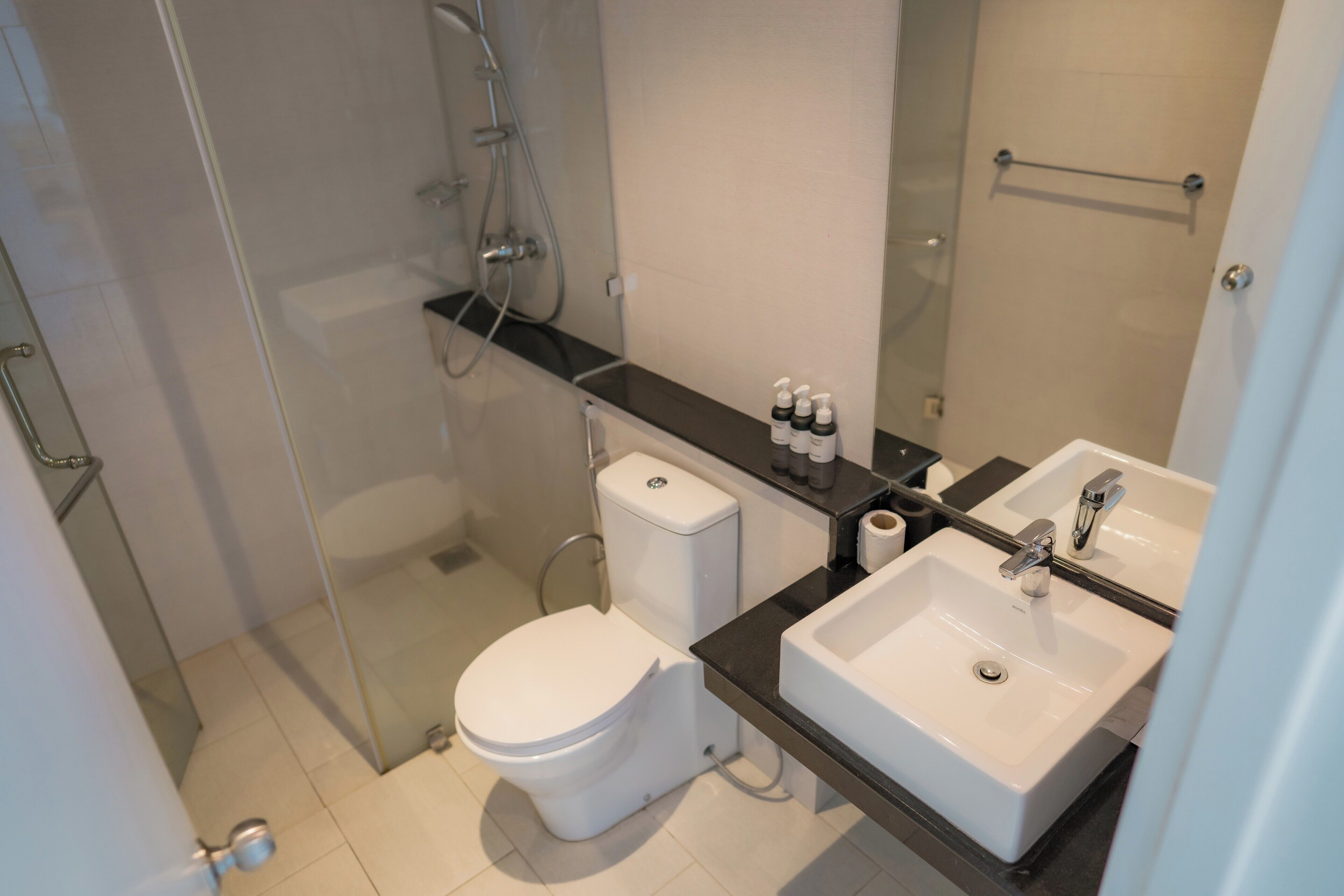 A modern bathroom with a toilet, sink, and shower.