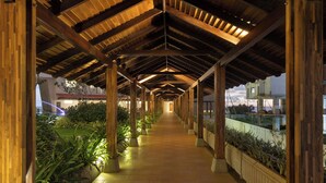 A covered walkway with wooden beams and potted plants on either side. - Oceanfront Galle by ICC (Galle)