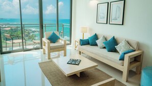 A modern living room with a large glass door leading to a balcony with a view of the ocean. - Oceanfront Galle by ICC (Galle)