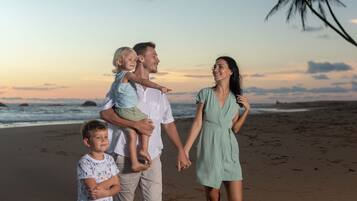 Eine Familie am Strand bei einem Sonnenuntergang.