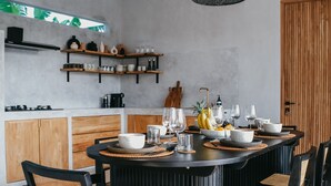 Una cocina moderna con una mesa de comedor redonda, sillas negras y armarios de madera.