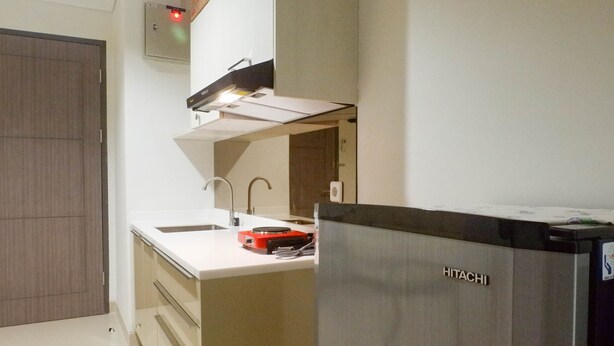 A modern kitchen with a stainless steel refrigerator, a white countertop, and a built-in oven. - Exclusive 1Br At Apartment Praxis (Surabaya)