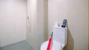 A bathroom with a shower, toilet, and a bidet. - Comfortable Pool View Studio Room at LRT City Jatibening Apartment (Bekasi)