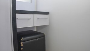Un piccolo ambiente chiuso con una panca nera e due cassetti bianchi, tutto su uno sfondo bianco.