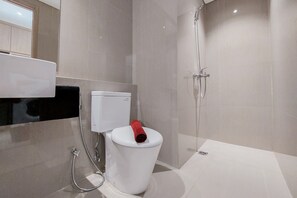 Ein modernes Badezimmer mit Toilette, Dusche und Handtuchhalter.