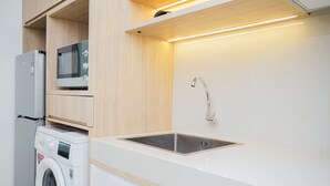 Eine moderne Küche mit integrierten Geräten, einer Edelstahl-Spüle und Holzschränken.