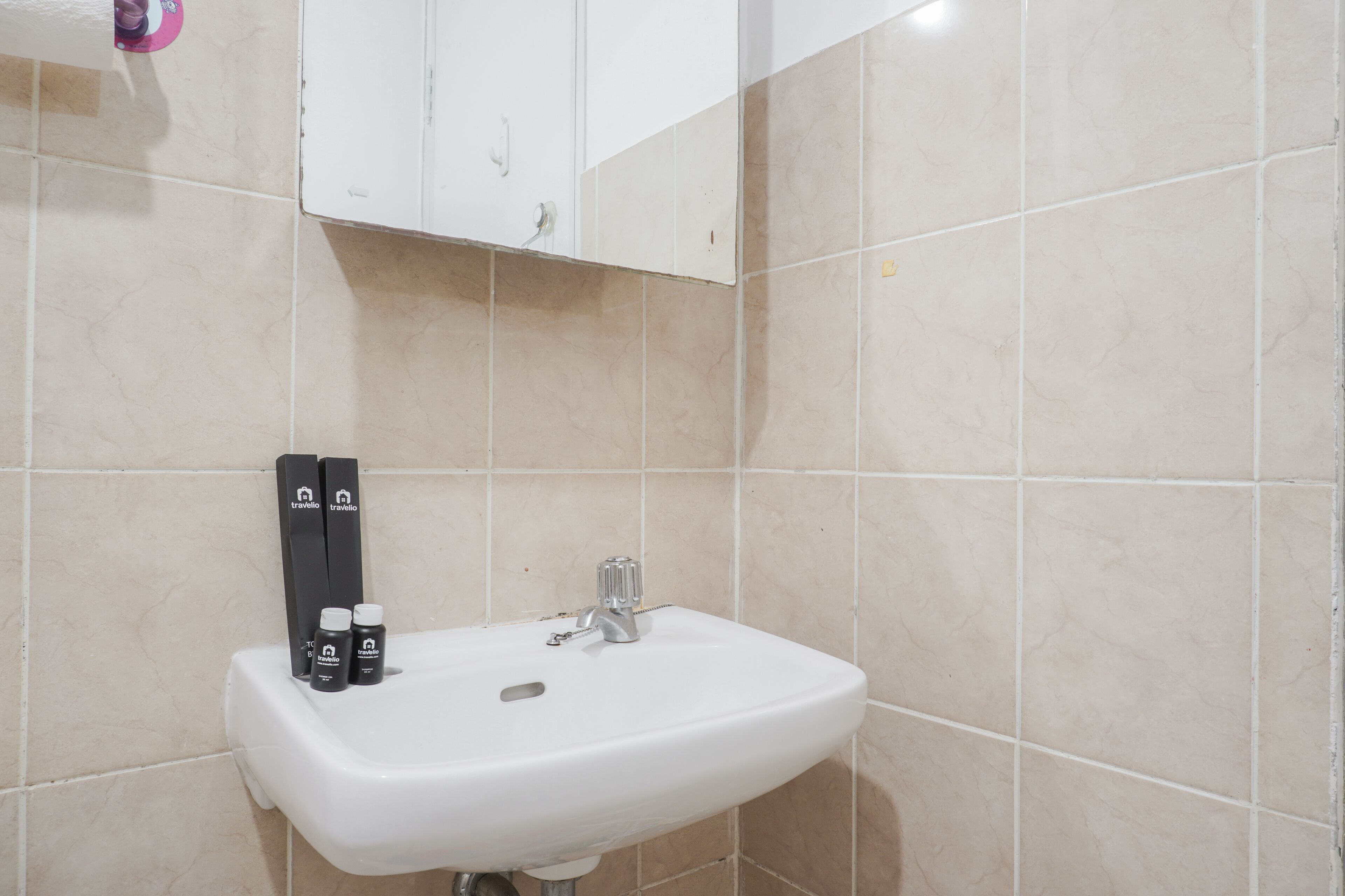 A bathroom with a white sink, two black toiletries, and a mirror above the sink.