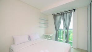 Una camera da letto con un letto, un tavolino e vista su un balcone.