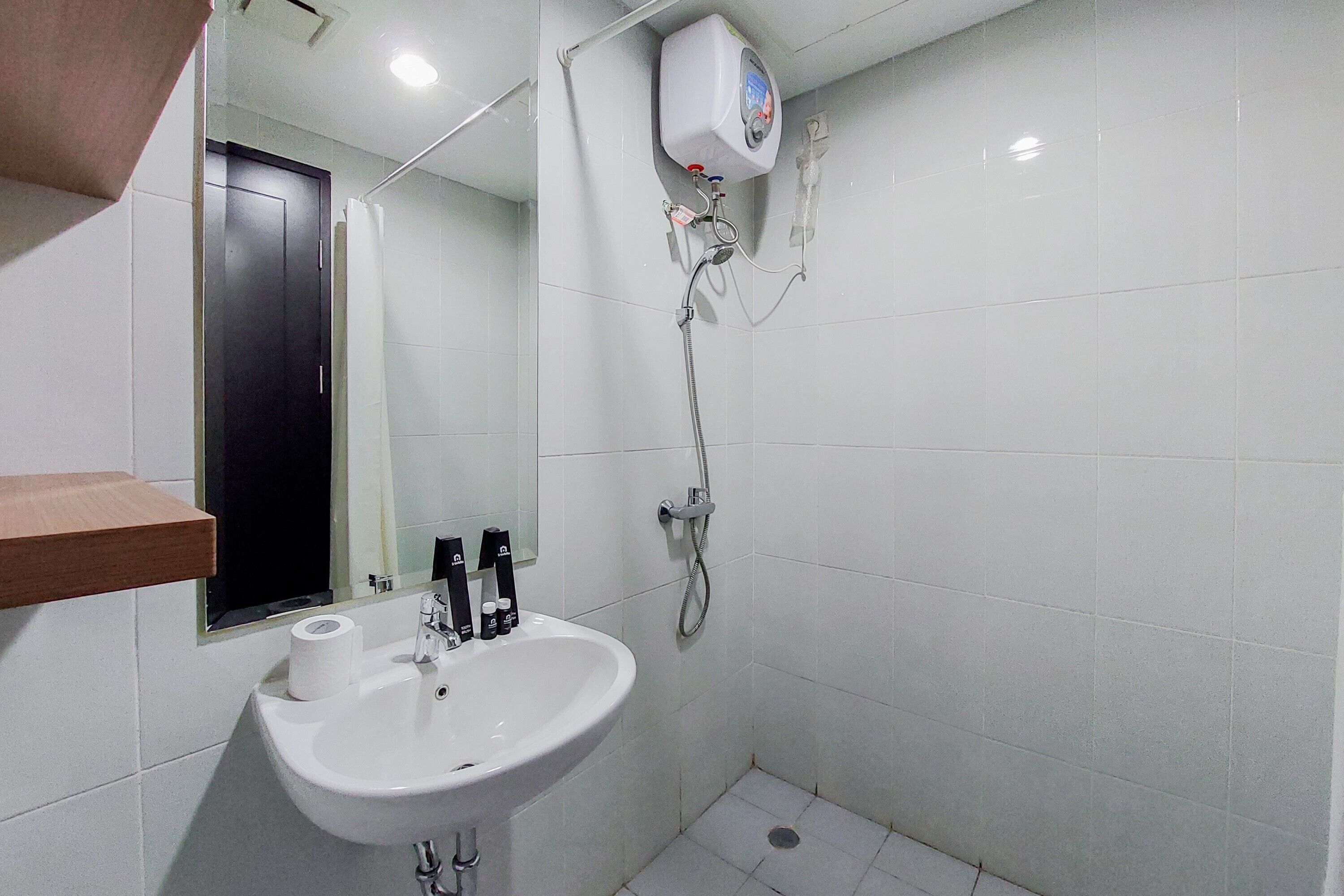 A bathroom with a white sink, a mirror, a shower, and a toilet.