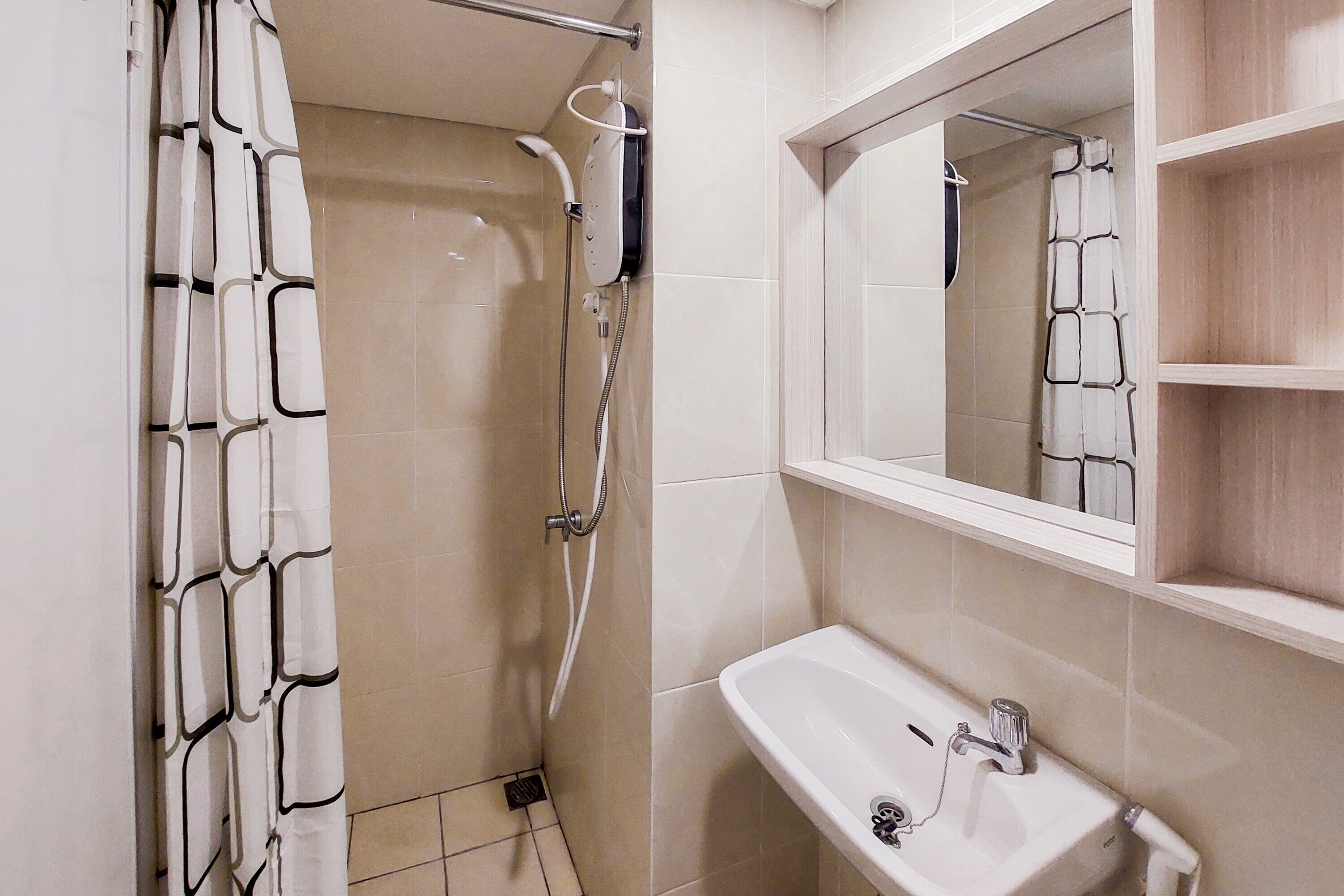 Un bagno con doccia, lavandino e specchio.