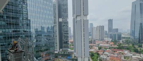 A high-rise building with a glass facade and a worker on a platform.