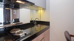 A modern kitchen with a black countertop, stainless steel appliances, and a built-in oven.