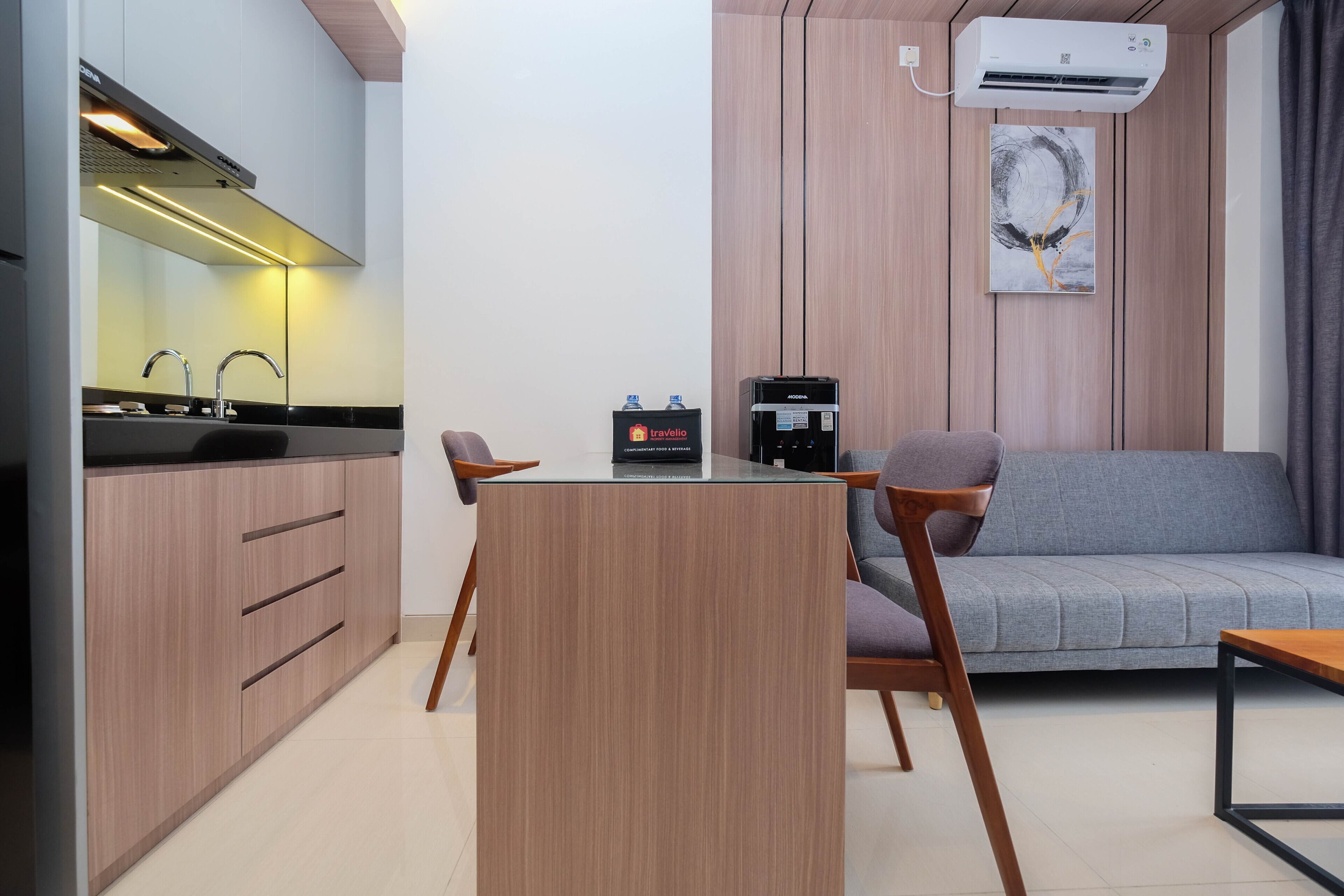 Une cuisine moderne équipée d’une cuisinière intégrée, d’une machine à café et d’un coin repas avec une table et des chaises.