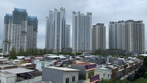 A residential area with high-rise apartment buildings and smaller houses. - Minimalist And Comfort Studio Apartment At Springhill Terrace Residence (Jakarta)