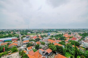 A residential area with red-tiled roofs, dense greenery, and a mix of modern and traditional architecture. - Comfortable And Cozy Living Studio Room Apartment At Dave (Depok)