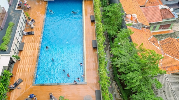 Luftaufnahme eines Dachpools mit darin schwimmenden und entspannten Personen.