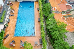 Luftaufnahme eines Dachpools mit darin schwimmenden und entspannten Personen.