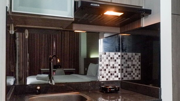 A modern kitchen with a stainless steel sink, a coffee machine, and a Modena range hood. - Cozy Stay Studio Apartment At Taman Melati Surabaya (Surabaya)