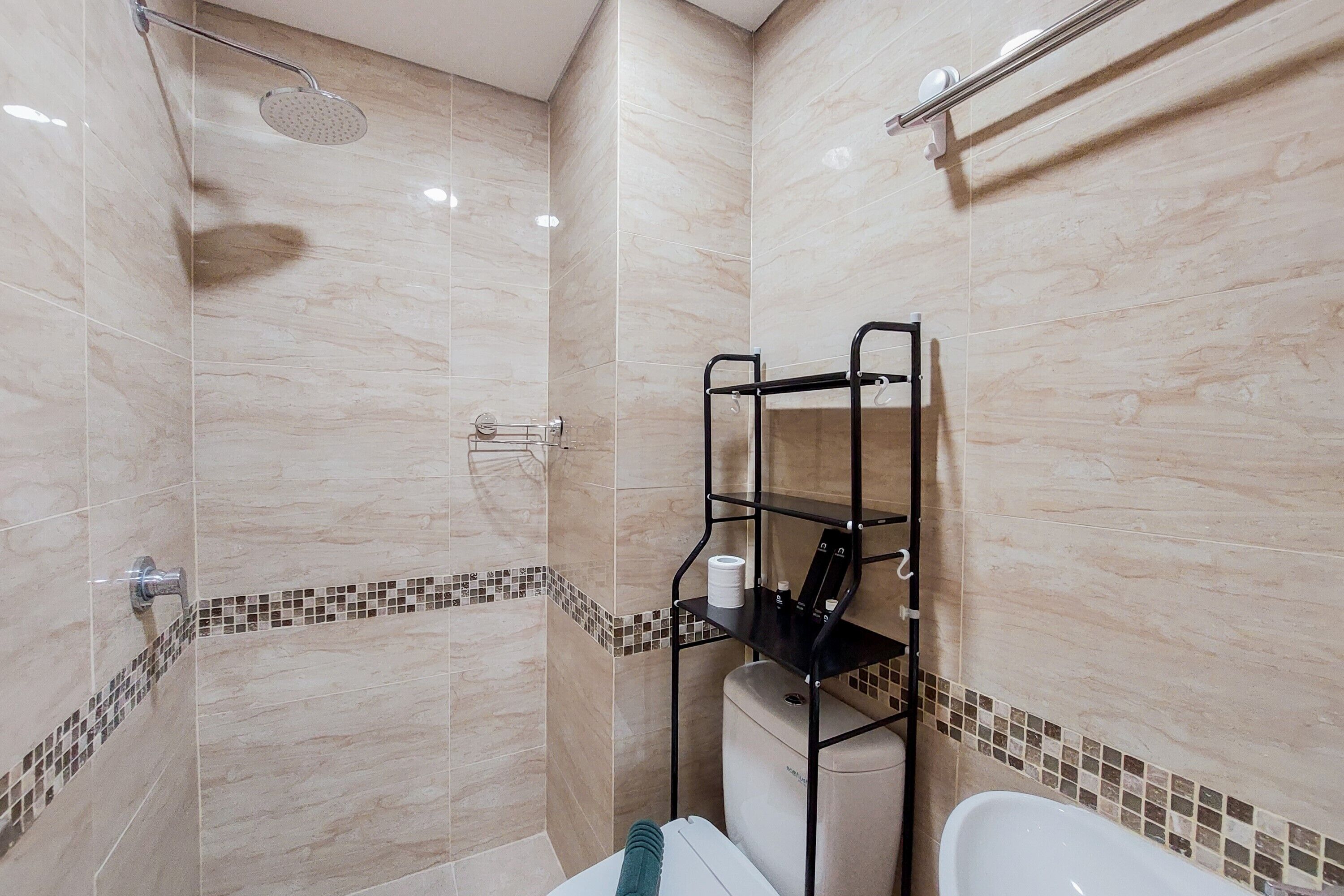Un baño con ducha, inodoro y un armario.