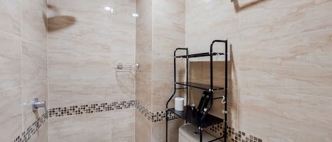 Un baño con ducha, inodoro y un armario.