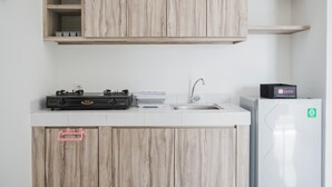 Una cocina moderna con armarios de madera, estufa a gas, pileta y refrigerador.