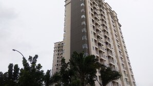 Un edificio residencial alto con varios balcones y ventanas.
