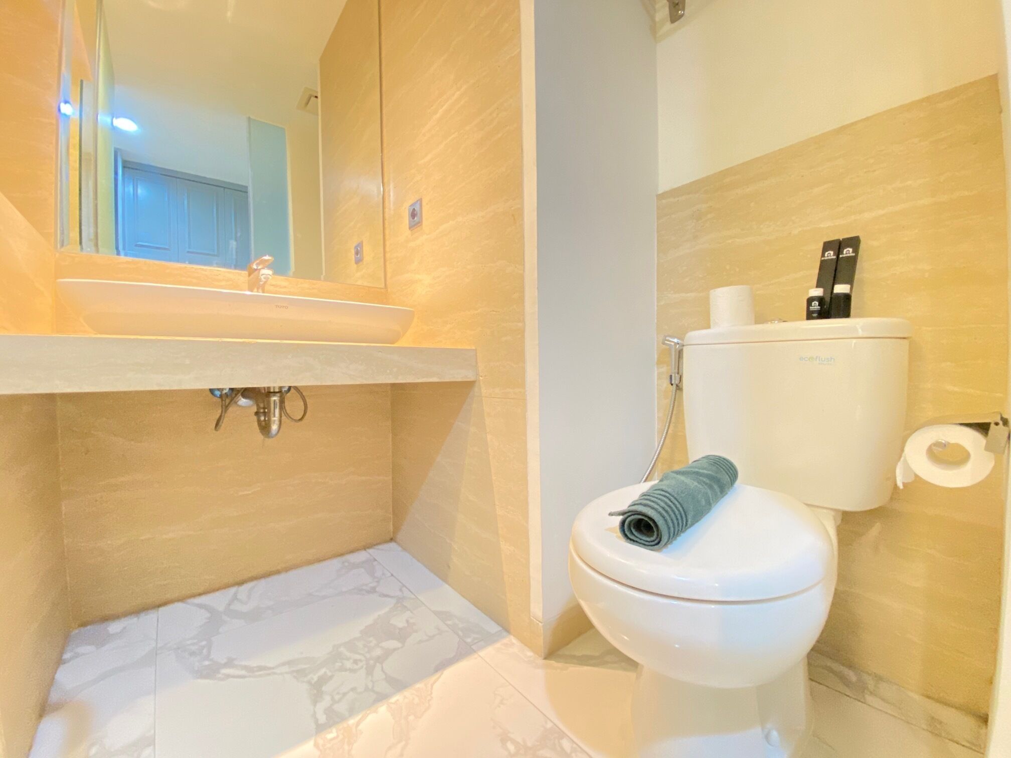 Ein Badezimmer mit Marmorwaschbecken, Toilette und Dusche.