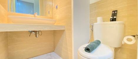 Ein Badezimmer mit Marmorwaschbecken, Toilette und Dusche.