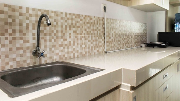 Een moderne keuken met een dubbele spoelbak, een kraan en een betegelde spatwand.