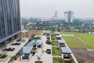A modern building with a rooftop garden featuring seating areas, solar panels, and a pathway.