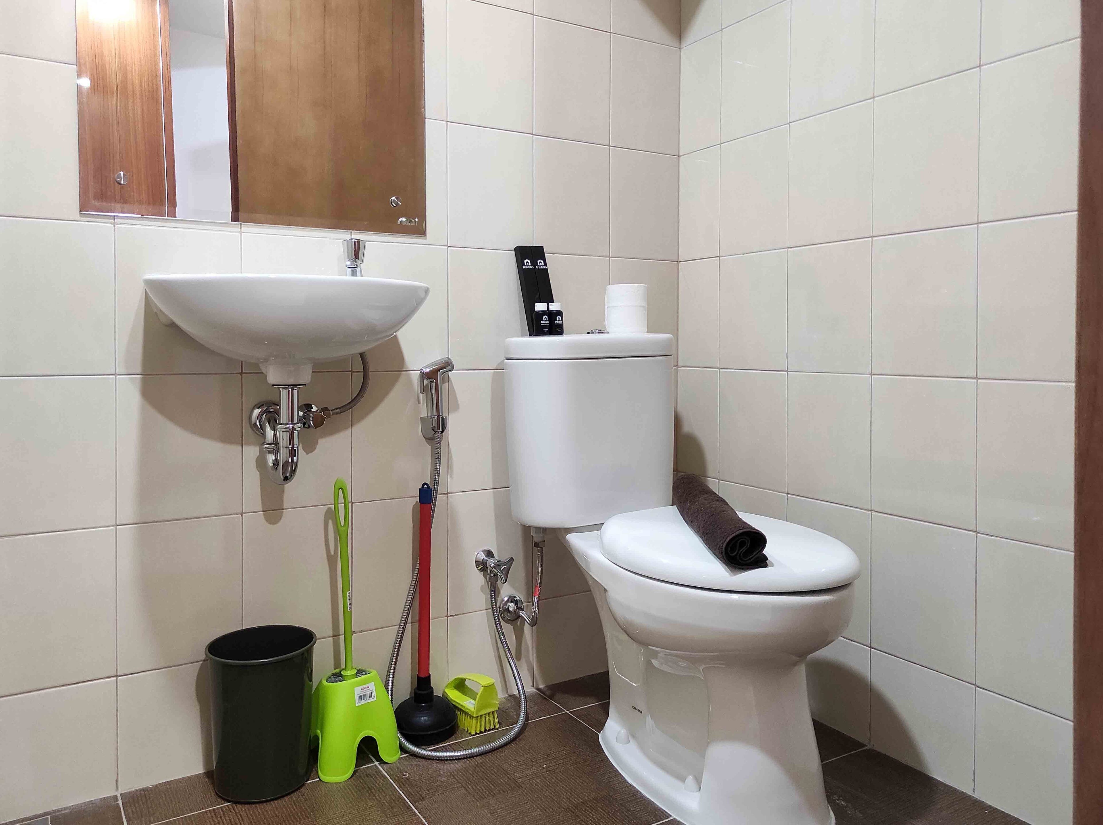 Ein Badezimmer mit weißem Waschbecken, Toilette und einem Holzschrank darüber.