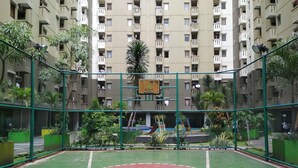 An indoor basketball court surrounded by a green fence, with a basketball hoop in the center. - Spacious Studio Apartment At Gateway Ahmad Yani Cicadas (Bandung)