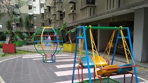 A playground with swings and a climbing structure in an urban setting. - Spacious Studio Apartment At Gateway Ahmad Yani Cicadas (Bandung)