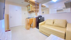 A compact living space with a kitchenette, a sofa, and a dining area. - Nice And Cozy 2Br Apartment At Parahyangan Residence (Bandung)