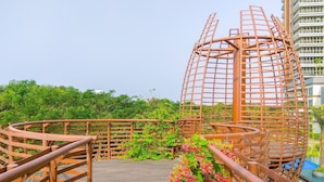 A wooden deck with a spiral staircase and a metal lattice structure. - Stunning And Strategic 2Br Gold Coast Apartment Near Pik (Jakarta)