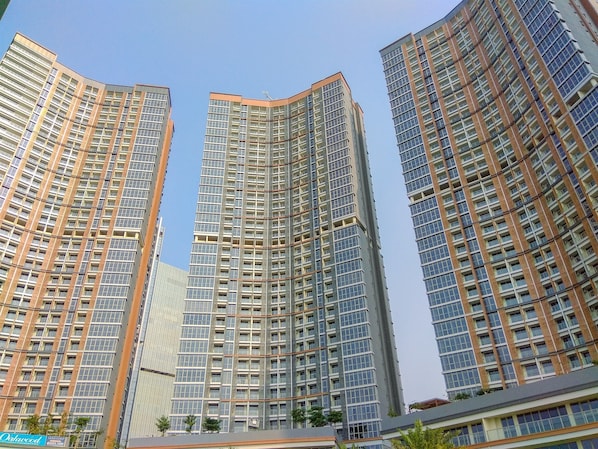 Three high-rise buildings with a modern architectural design, featuring numerous windows and a uniform facade.