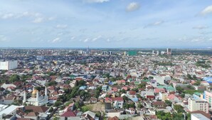A densely populated urban area with a prominent mosque featuring a golden dome and two minarets. - Convenient Studio At Vida View Makassar (Makassar)