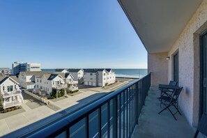 Un balcon avec vue sur la plage et les maisons.