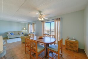 A dining area with a round table, chairs, and a ceiling fan. - Simple North Wildwood Condo - Steps to Beach! (North Wildwood)