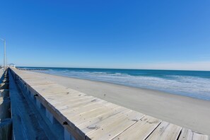 A wooden boardwalk leading to a beach with clear blue skies. - Simple North Wildwood Condo - Steps to Beach! (North Wildwood)