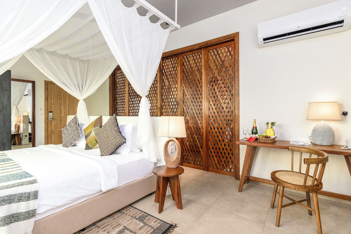 A bedroom with a bed, bedside table, chair, and a wooden partition.