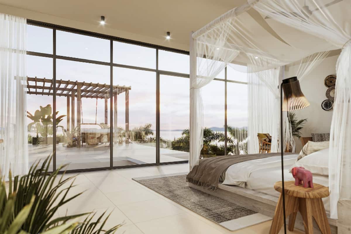A modern bedroom with a large bed, a canopy, and a view of the outdoors.