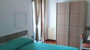 A room with a bed, a wardrobe, a radiator, and a window with curtains. - Miscale House (Cattolica Eraclea)