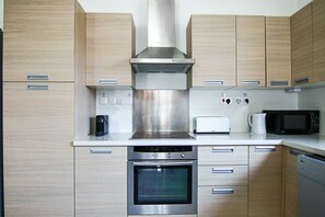 Apartamento de lujo | Cocina privada | Frigorífico, hervidor eléctrico y mesa de comedor